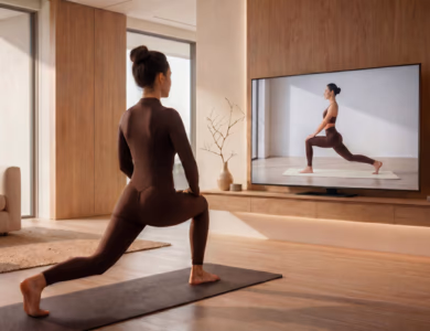 Woman doing a guided lunge stretch on a yoga mat while following a BetterMe app workout on a TV screen at home
