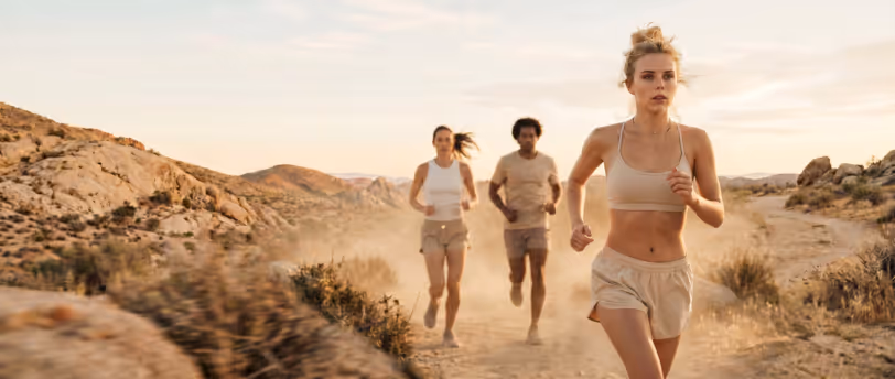 Colleagues running together on a desert trail at sunset as part of a corporate wellness step challenge